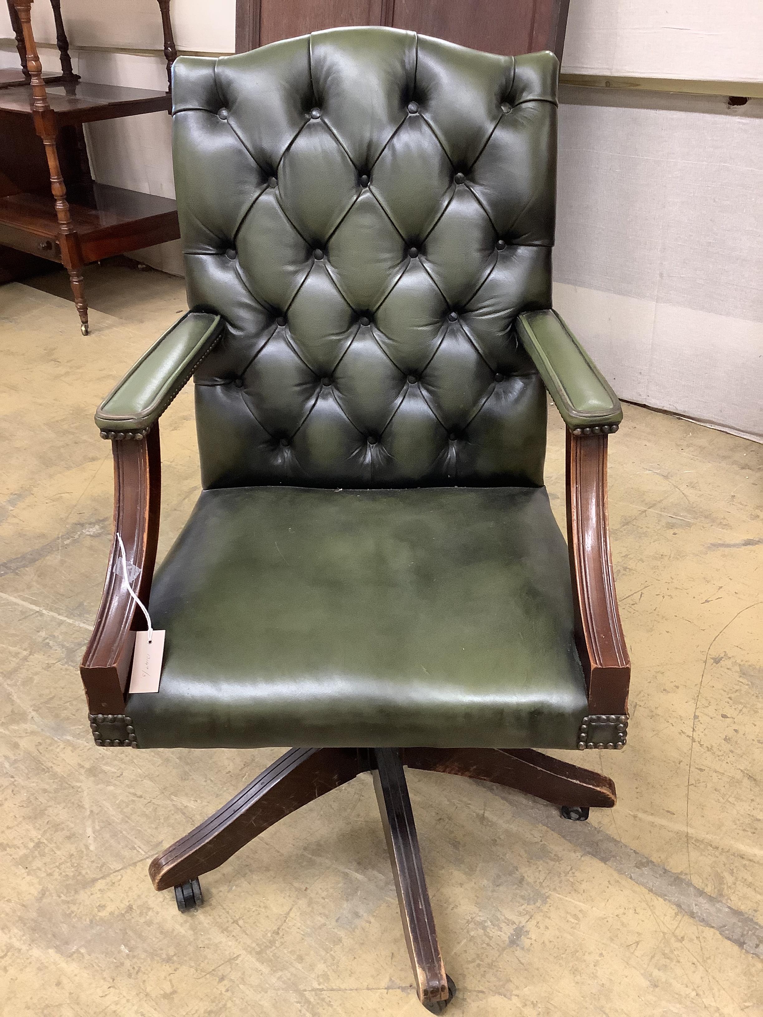A reproduction mahogany and buttoned green leather swivel desk chair, width 60cm, depth 58cm, height 106cm